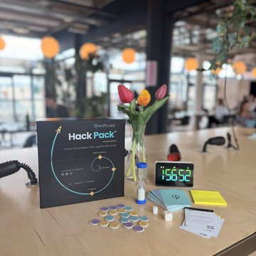 The Hack Pack on a table: box, sand timer, evidence chips, dice, role cards and the countdown clock
