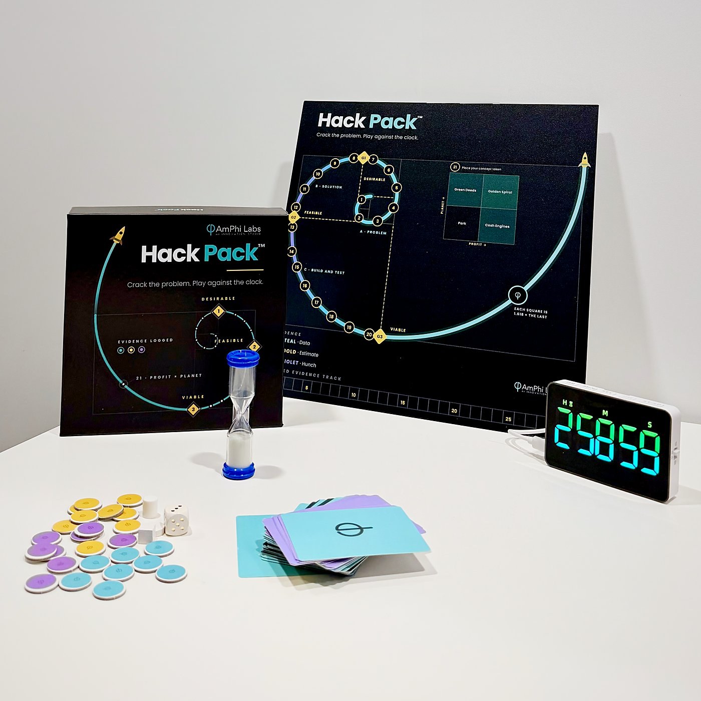 De echte Hack Pack op tafel: doos, speelbord, zandloper, bewijsfiches, kaarten en de aftelklok